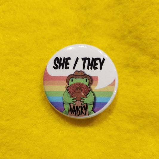 Whisky Frog Pronoun Button | SHE/THEY | 1.25" - Deviantkreations